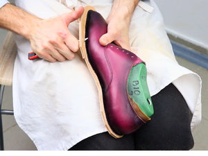 Shoemaker working on a handmade burgundy leather shoe using a last – step-by-step lesson from the VALEVRO shoemaking course.