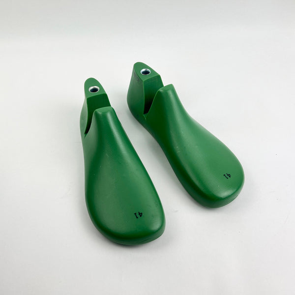 Pair of green shoe last on a white background