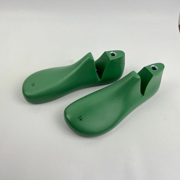 Pair of green shoe last on a white background