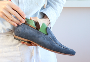 Craftsman shaping a handmade blue suede loafer during the VALEVRO online shoemaking course.