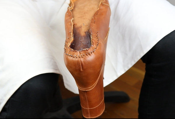 Close-up of a brown ankle boot with iron nails inserted in lasting allowance in heel area