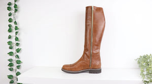 a brown leather high calf boots with zipper at inside
