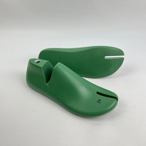 Pair of green shoe last on a white background
