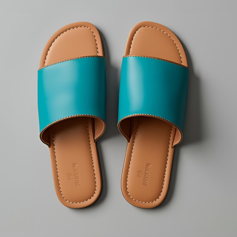 A pair of turquoise leather sandals, with a clean gray background